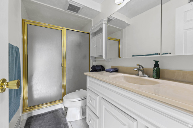 5896 South 3950th Street West Roy, UT 84067 - Photo 14 of 29 Full bathroom featuring vanity, a shower stall, and light tile patterned floors