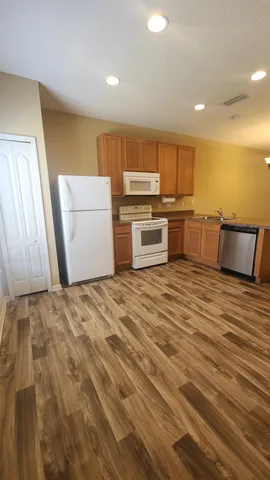 a kitchen with a refrigerator and a stove top oven