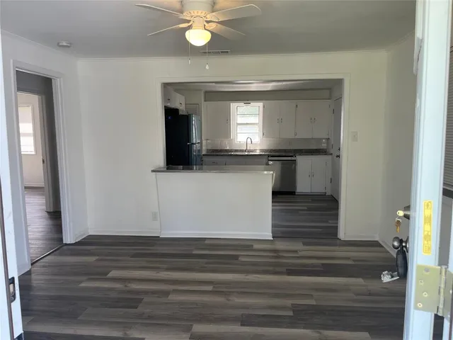 a view of a hallway with wooden floor and staircase