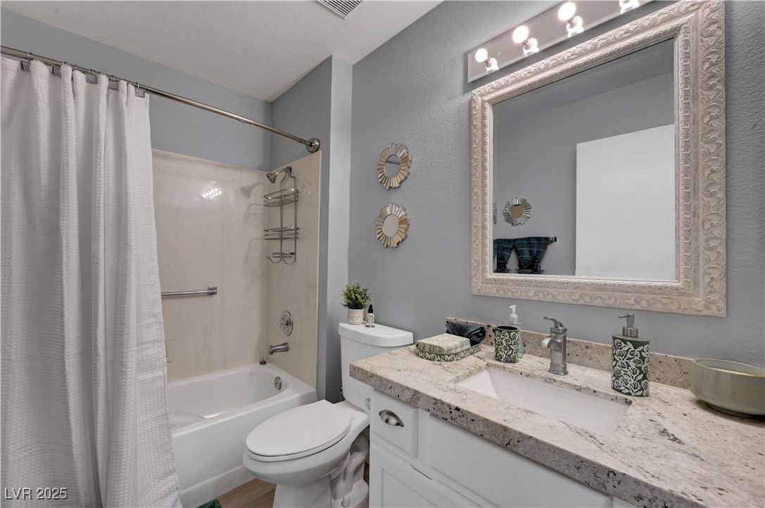 Undisclosed Address Las Vegas, NV 89134 - Photo 11 of 39 Bathroom with shower / bathtub combination with curtain, vanity, and a textured wall