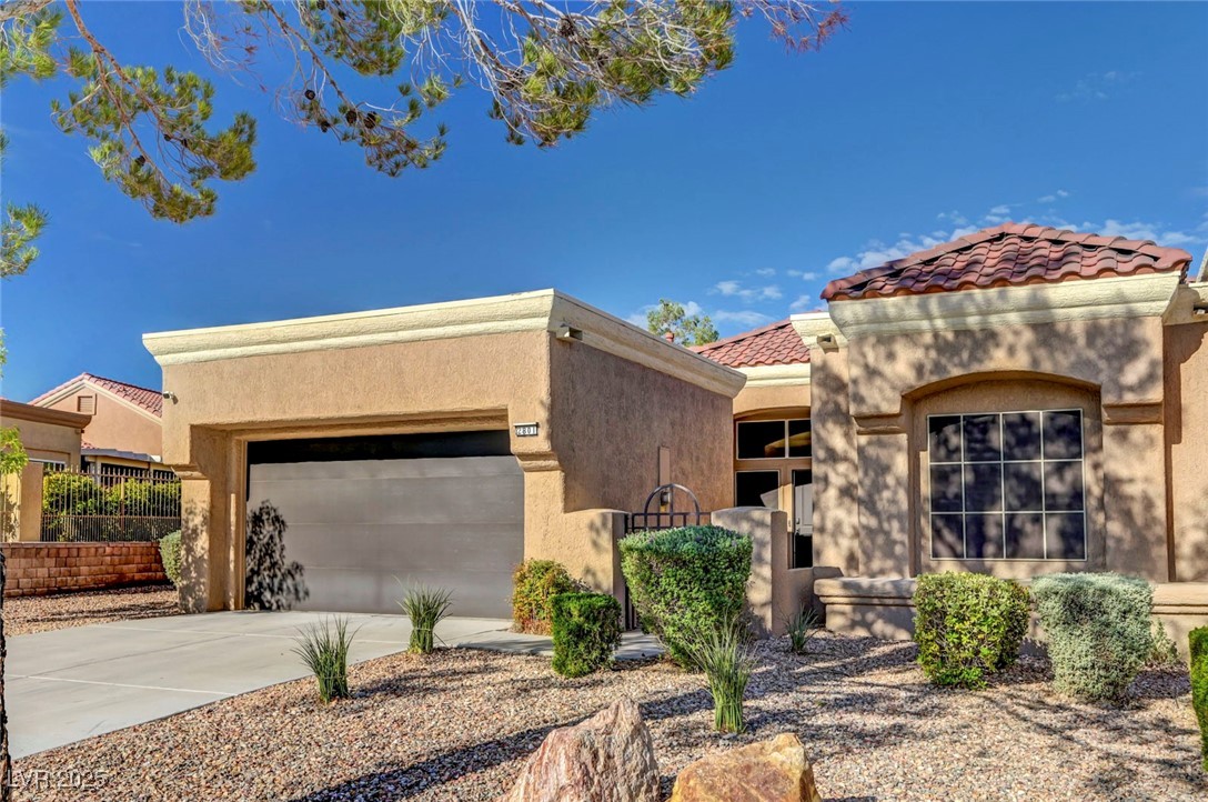 Undisclosed Address Las Vegas, NV 89134 - Photo 2 of 39 View of front facade featuring stucco siding, driveway, a tiled roof, and a garage