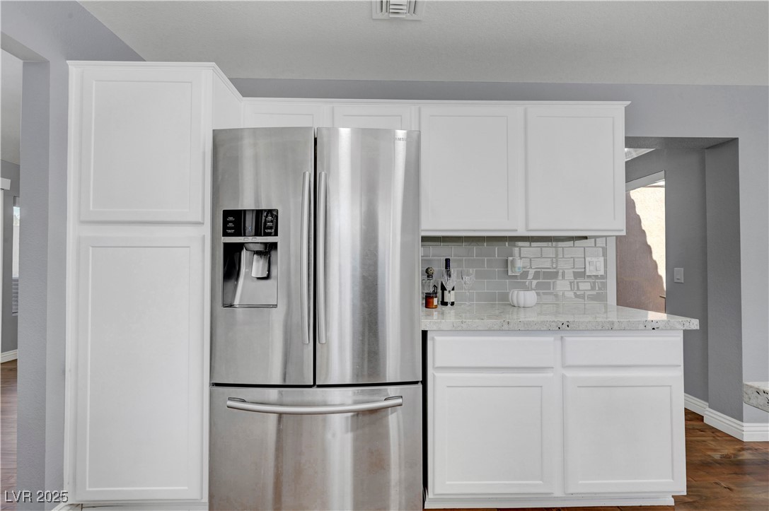 Undisclosed Address Las Vegas, NV 89134 - Photo 26 of 39 Kitchen featuring stainless steel fridge, wood finished floors, and white cabinetry