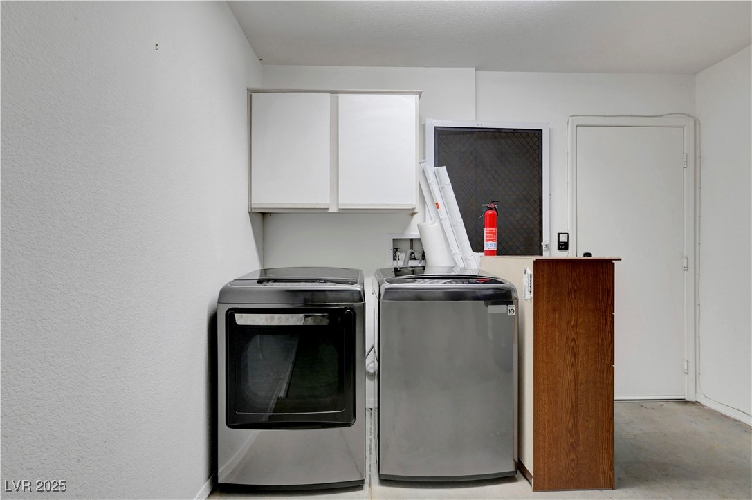 Undisclosed Address Las Vegas, NV 89134 - Photo 28 of 39 Laundry room with cabinet space, washer and dryer, and a textured wall