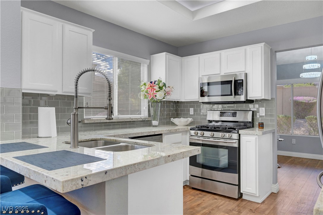 Undisclosed Address Las Vegas, NV 89134 - Photo 3 of 39 Kitchen featuring stainless steel appliances, white cabinets, and a peninsula