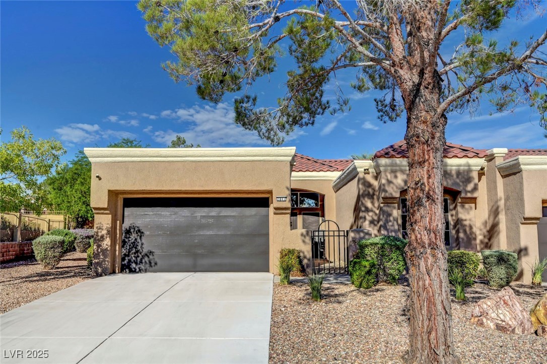Undisclosed Address Las Vegas, NV 89134 - Photo 31 of 39 View of front of property with stucco siding, a tiled roof, concrete driveway, and a garage