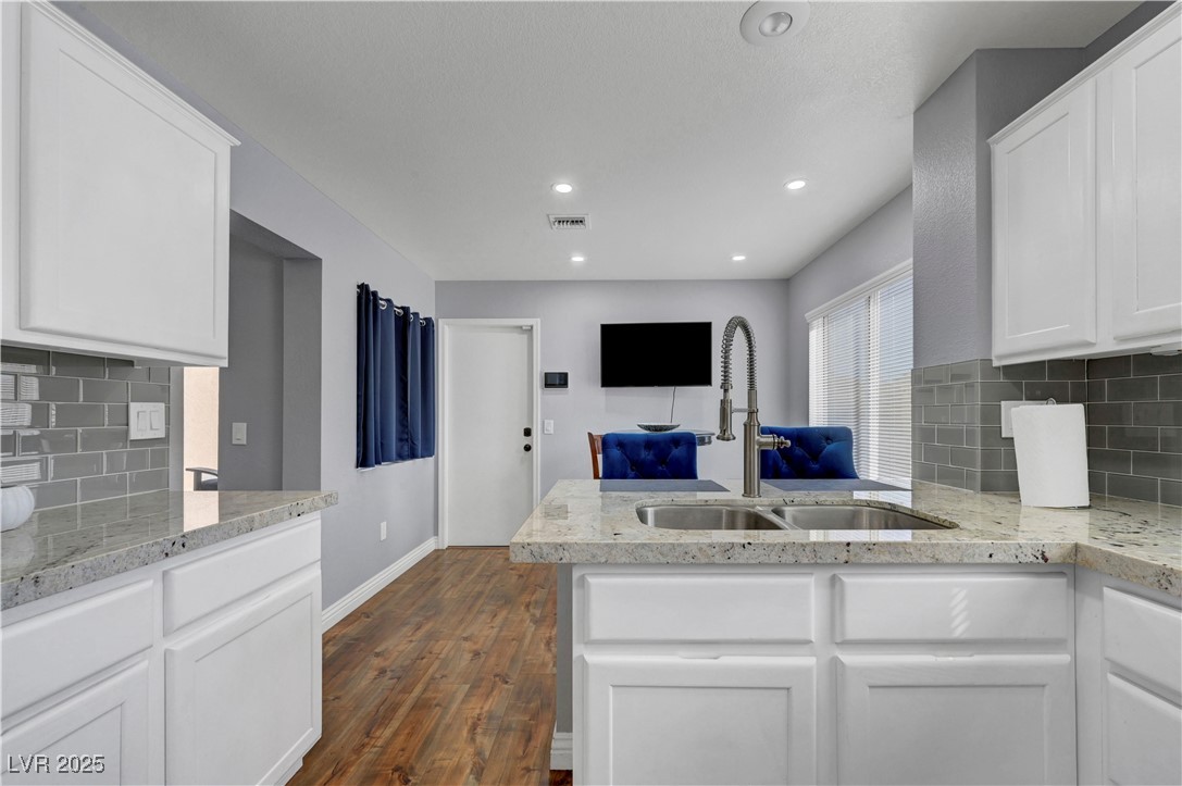 Undisclosed Address Las Vegas, NV 89134 - Photo 5 of 39 Kitchen featuring decorative backsplash, white cabinetry, a peninsula, light stone countertops, and recessed lighting