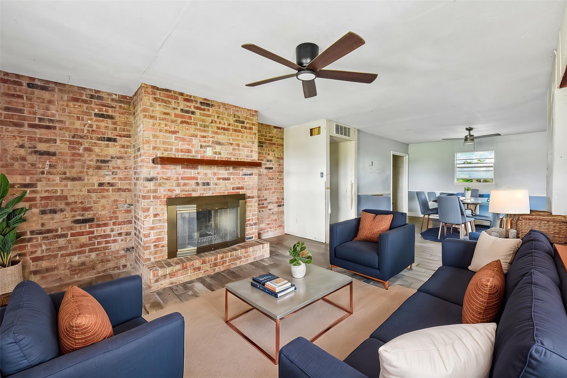 1111 Silent Valley Road Lockhart, TX 78644 - Photo 2 of 14 A spacious living area featuring a prominent brick fireplace and rich hardwood flooring.