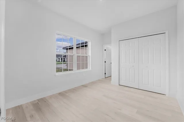 an empty room with windows and closet