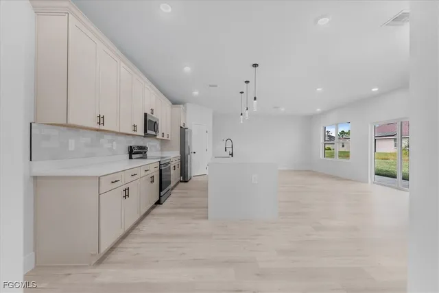 a large white kitchen with cabinets and a refrigerator