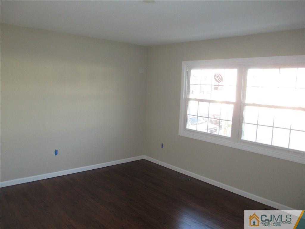 77 Middle Hill Road Colonia, NJ 07067 - Photo 11 of 21 an empty room with wooden floor and windows