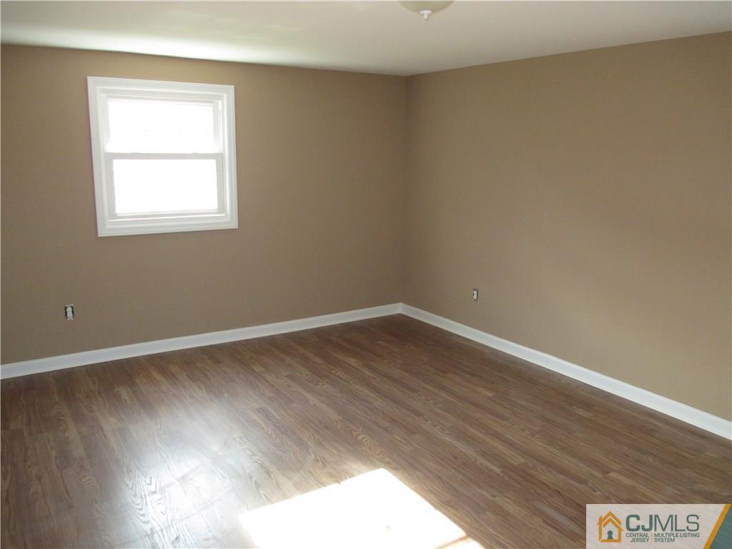 77 Middle Hill Road Colonia, NJ 07067 - Photo 12 of 21 a view of an empty room with wooden floor and a window