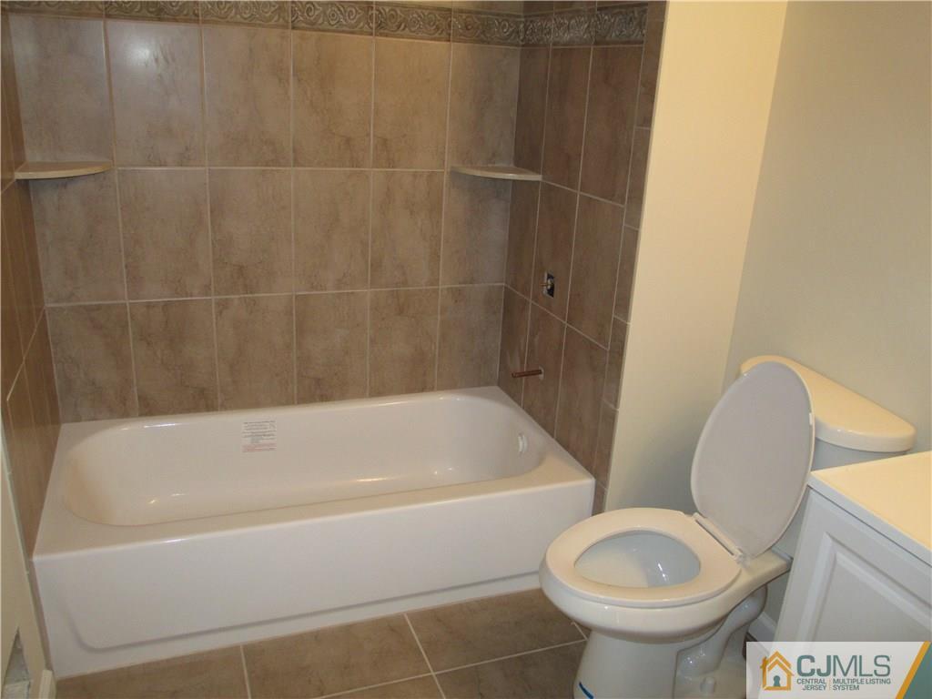 77 Middle Hill Road Colonia, NJ 07067 - Photo 8 of 21 a white bath tub sitting next to a toilet
