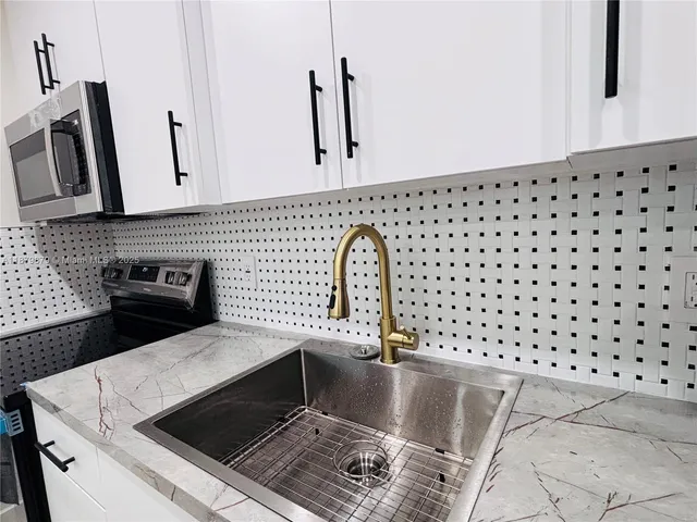 a close view of a sink a counter and appliances in the kitchen