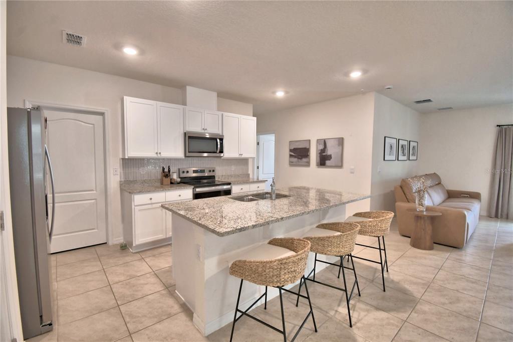 2839 Moulin Road Davenport, FL 33837 - Photo 14 of 75 a kitchen with a sink a counter top space cabinets and stainless steel appliances
