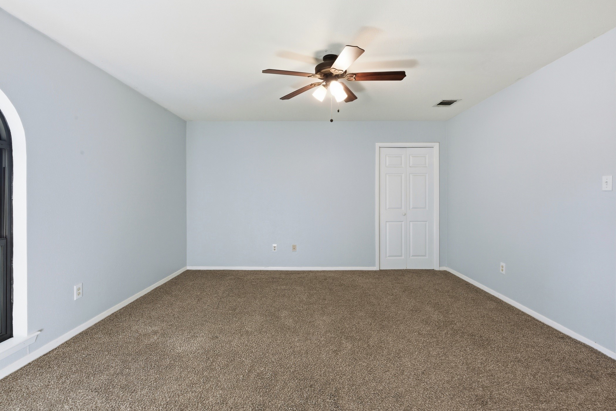 3721 Avenue R Rosenberg, TX 77471 - Photo 26 of 43 Primary bedroom with recent carpet, ceiling fan, and neutral paint for easy decorating. Here you see the door for 1 of 2 closets in the primary suite.