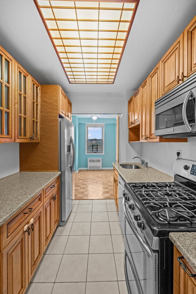 2400 Johnson Avenue, Unit 2F Bronx, NY 10463 - Photo 11 of 25 a kitchen with stainless steel appliances granite countertop a stove a sink dishwasher and granite countertops with a flat screen tv