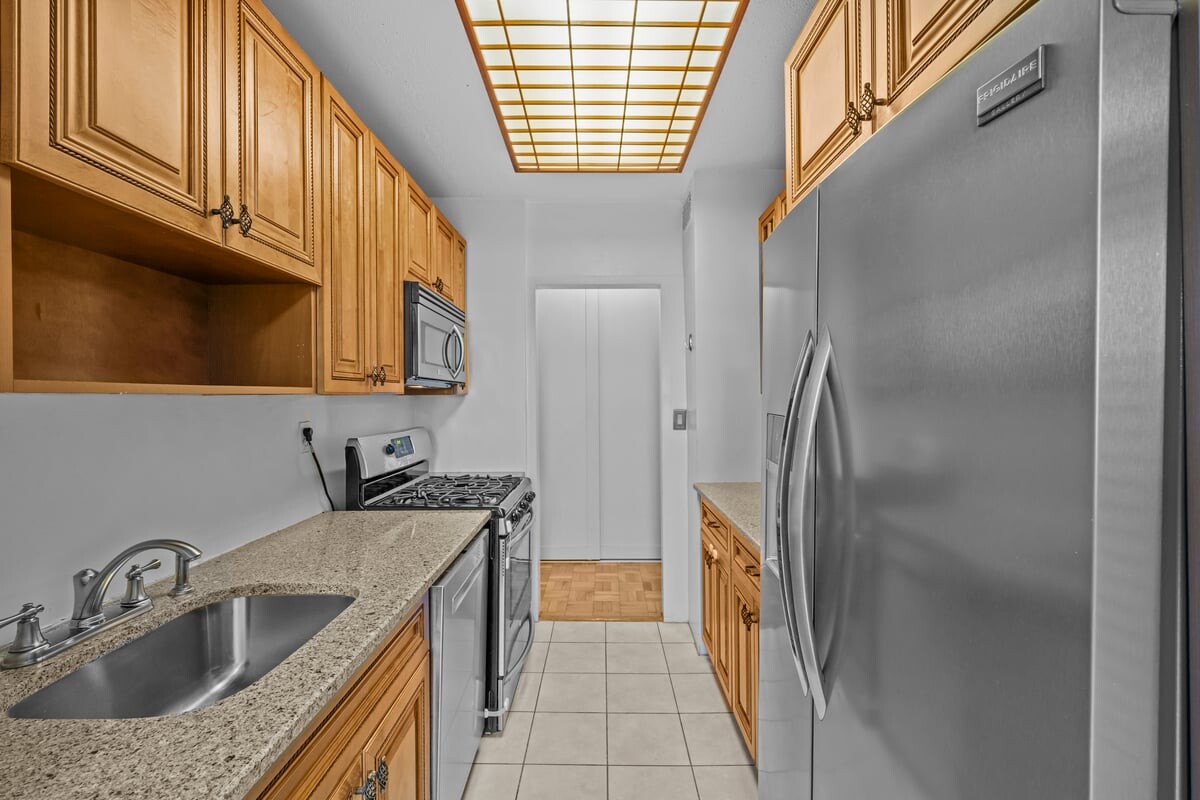 2400 Johnson Avenue, Unit 2F Bronx, NY 10463 - Photo 12 of 25 a kitchen with stainless steel appliances granite countertop a sink a refrigerator and a stove