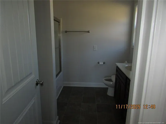 a bathroom with a granite countertop toilet and a sink