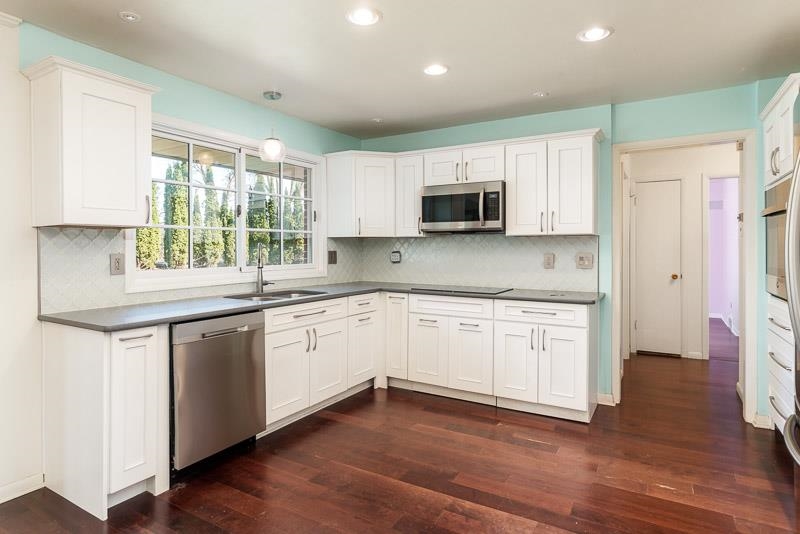 2309 Harris Road Rockford, IL 61107 - Photo 19 of 42 a kitchen with kitchen island granite countertop a sink cabinets and a wooden floor