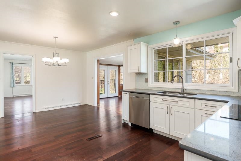 2309 Harris Road Rockford, IL 61107 - Photo 23 of 42 a kitchen with granite countertop a stove a sink and white cabinets with wooden floor next to windows