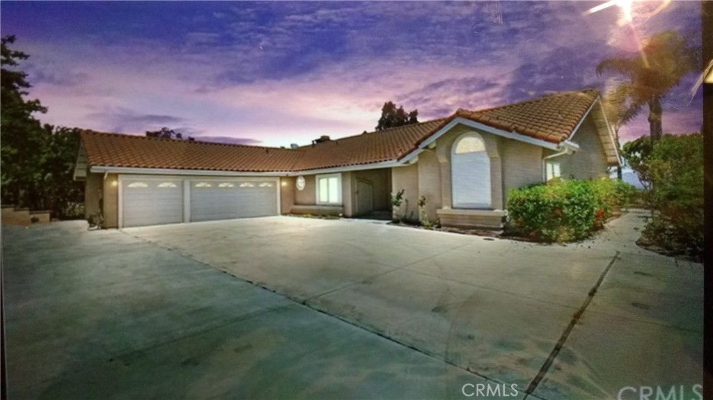 11056 Orchard View Lane Riverside, CA 92503 - Photo 2 of 10 a front view of a house with a yard and garage