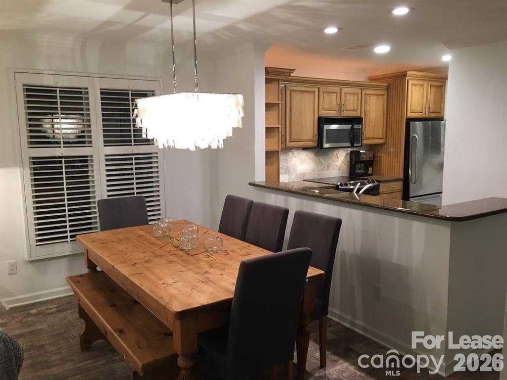646 Portside Drive Davidson, NC 28036 - Photo 7 of 48 a kitchen with stainless steel appliances a stove a refrigerator a sink a kitchen island with a dining table and chair