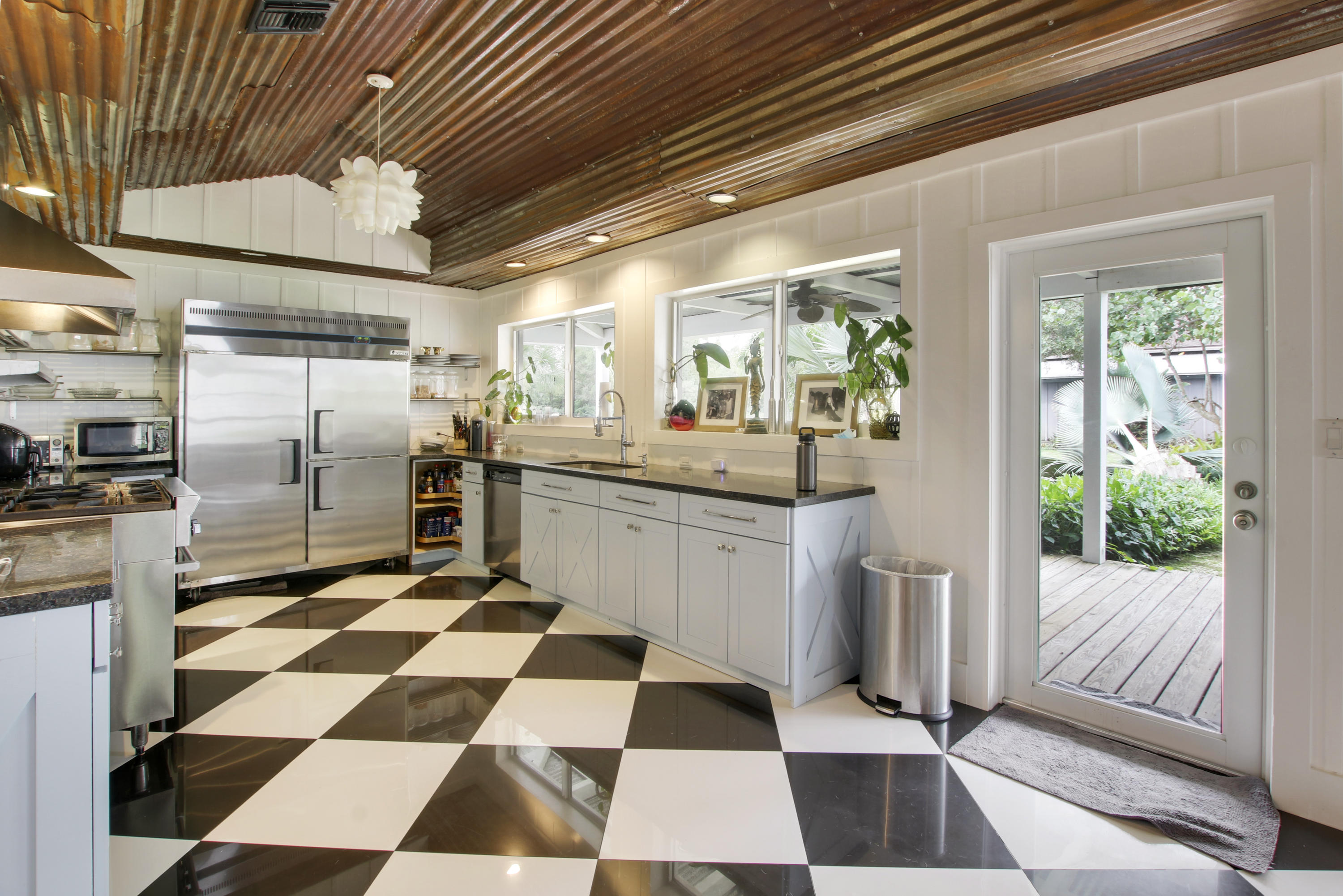18600 Southeast Mack Dairy Road Jupiter, FL 33478 - Photo 18 of 36 a kitchen with a checkered floor and white cabinets