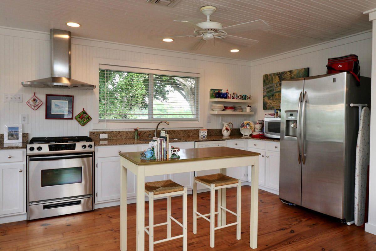 18600 Southeast Mack Dairy Road Jupiter, FL 33478 - Photo 34 of 36 a kitchen with kitchen island granite countertop a stove a sink a refrigerator wooden floor and cabinets