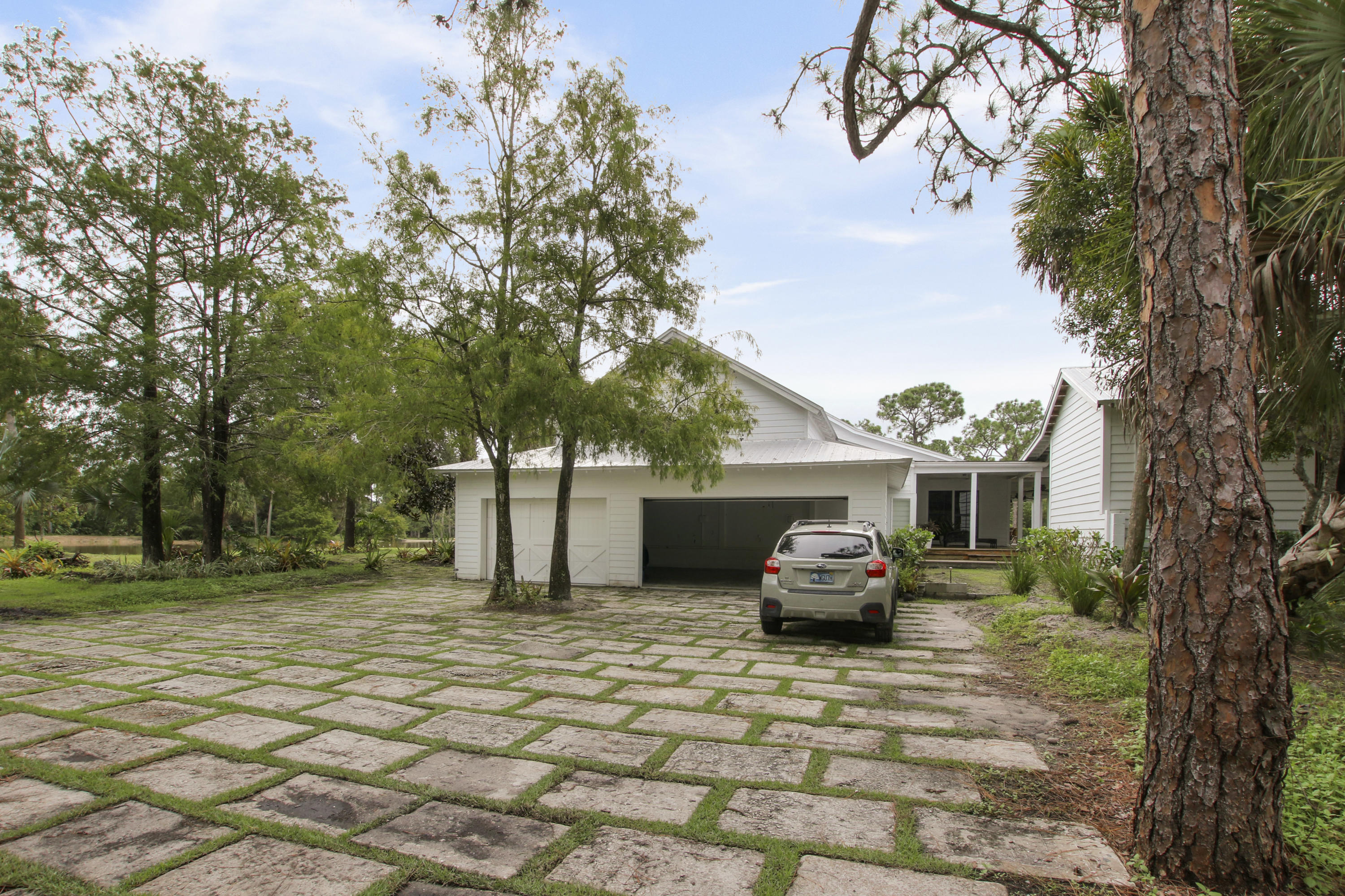 18600 Southeast Mack Dairy Road Jupiter, FL 33478 - Photo 7 of 36 a front view of a house with a garden