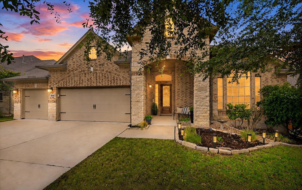 3016 Burcott Mill Road Pflugerville, TX 78660 - Photo 1 of 1 A welcoming brick and stone facade greets you, illuminated by a vivid sunset sky.