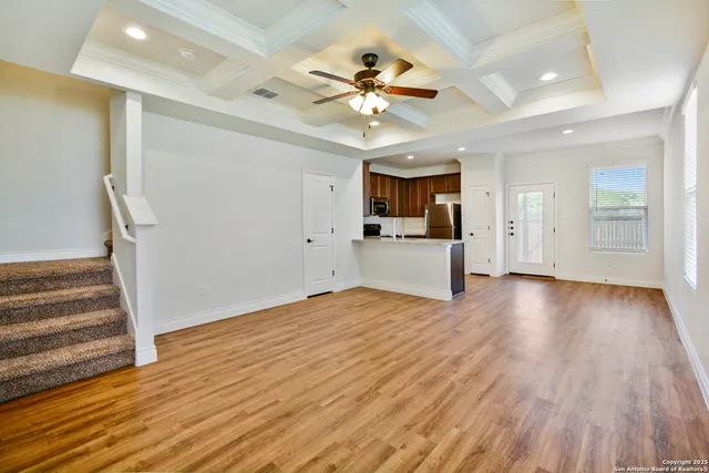 a view of a kitchen with wooden floor and a ceiling fan