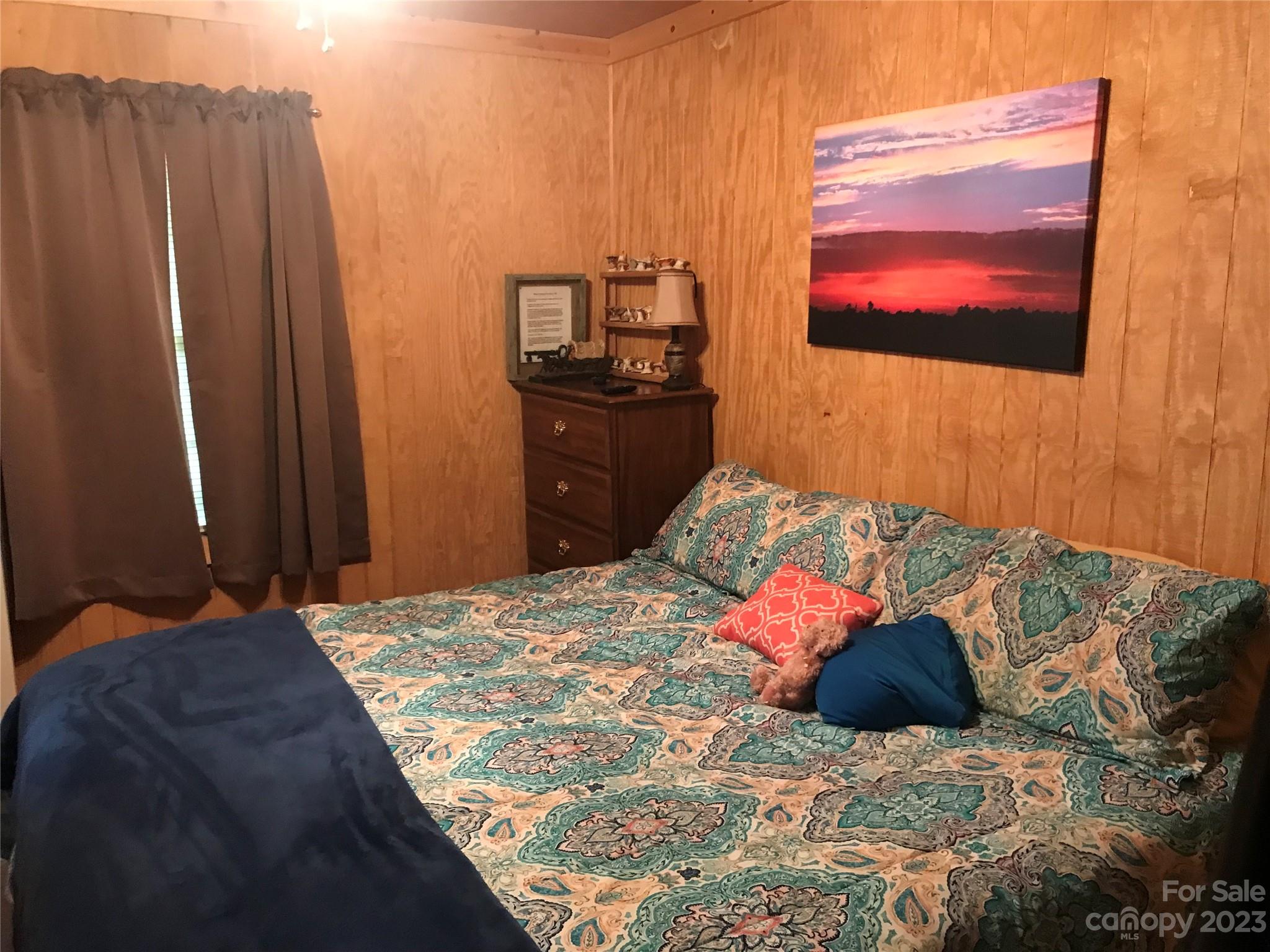 154 Roberts Ridge Road Mount Gilead, NC 27306 - Photo 23 of 35 a bedroom with a bed and a flat screen tv