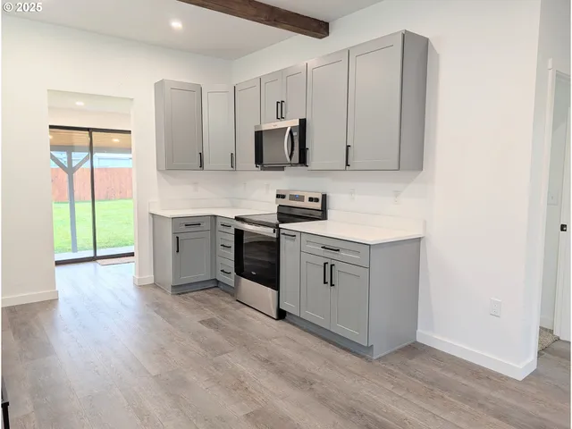 a kitchen with a sink cabinets and wooden floor