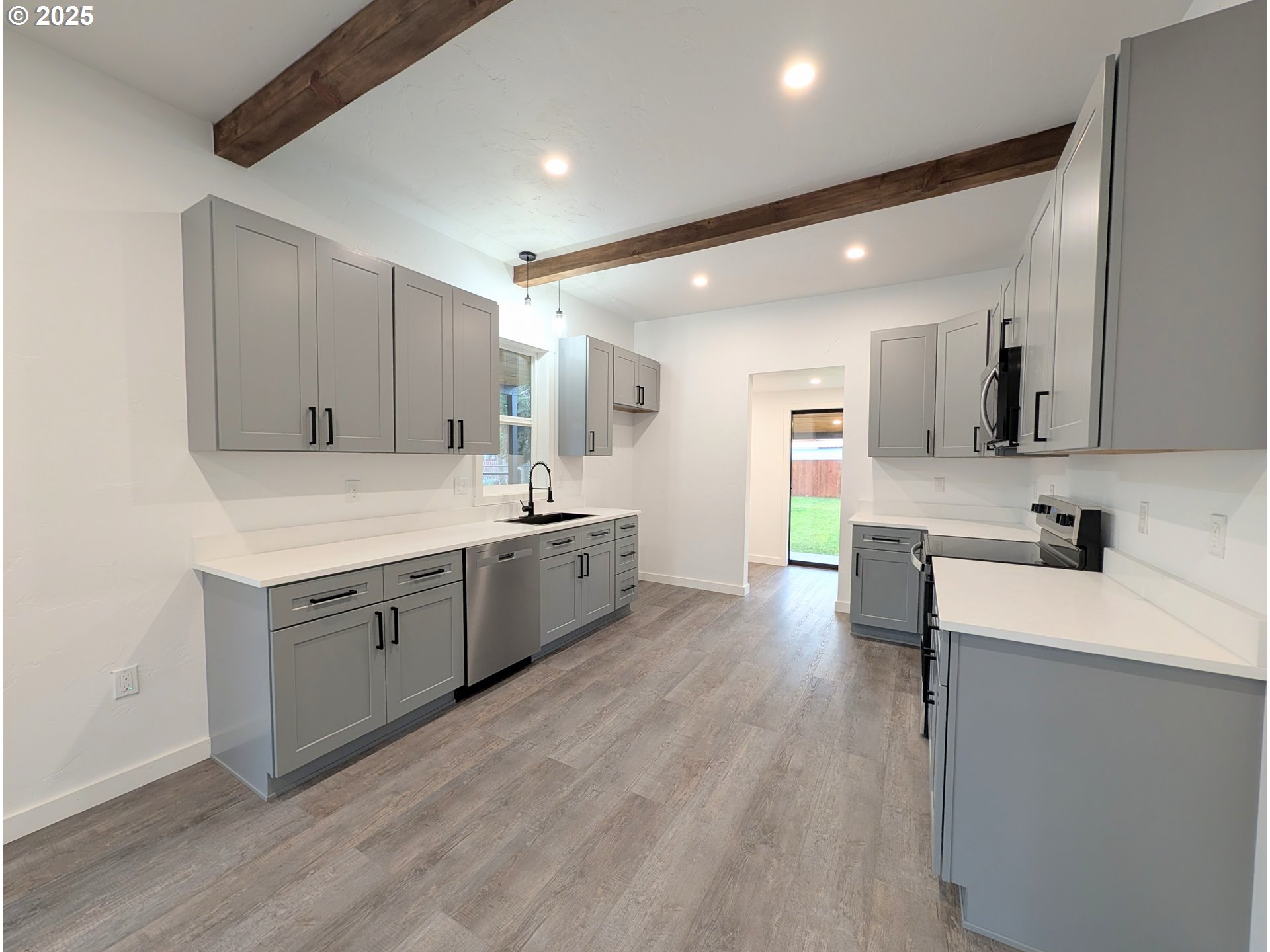 2906 North Oak Street La Grande, OR 97850 - Photo 9 of 37 a large kitchen with stainless steel appliances sink a microwave and cabinets