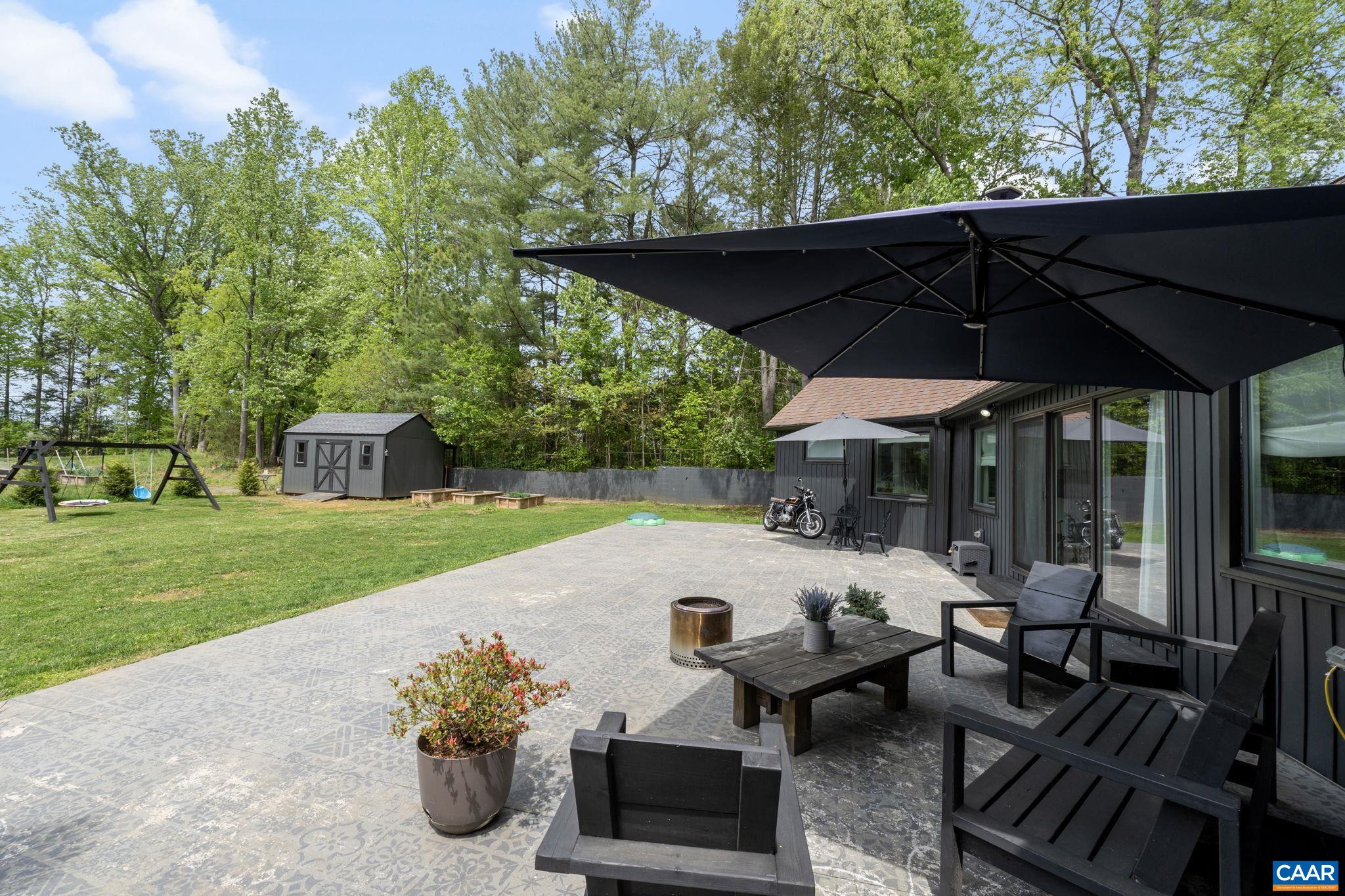 72 Daddy Rabbit Court Ruckersville, VA 22968 - Photo 67 of 71 a view of a patio with table and chairs under an umbrella