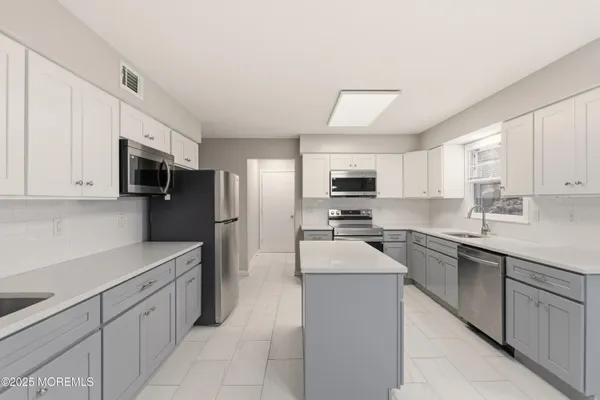 a kitchen with stainless steel appliances a sink dishwasher stove refrigerator and microwave