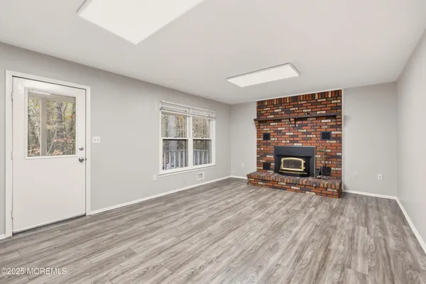 a view of empty room with wooden floor and fireplace