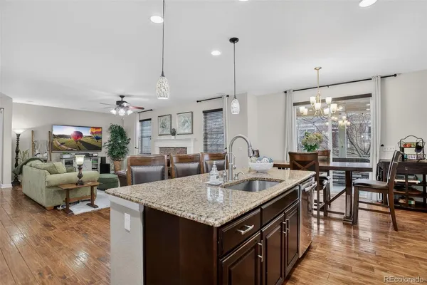 a open kitchen with stainless steel appliances granite countertop stove top oven and couches