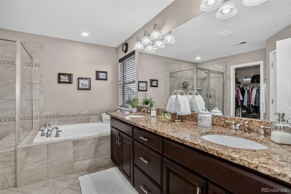 a bathroom with a granite countertop sink a large mirror and a bathtub