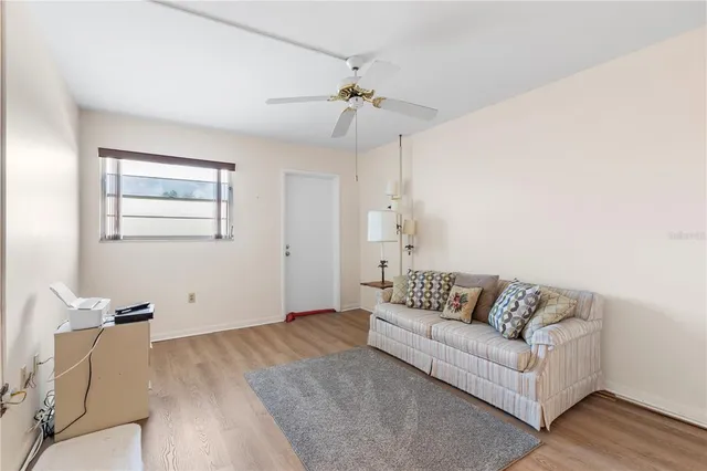 a living room with furniture and a ceiling fan