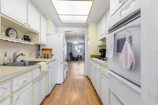 a kitchen with cabinets a sink and appliances
