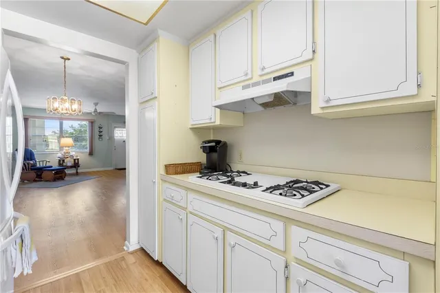 a kitchen with white cabinets and appliances
