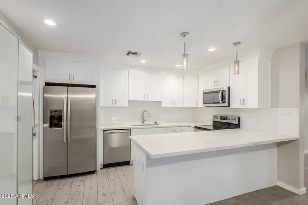 a kitchen with stainless steel appliances a refrigerator sink and microwave