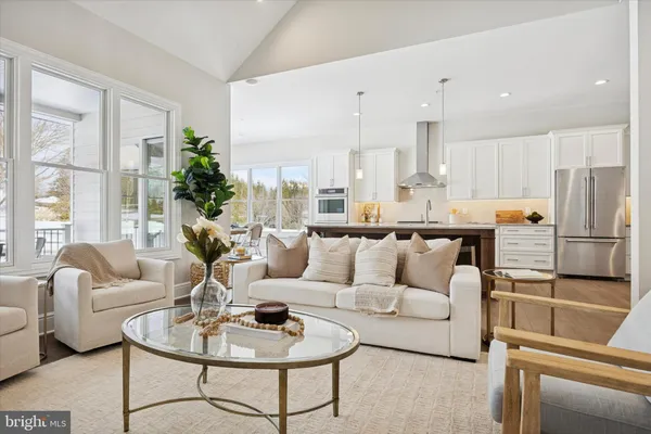 a living room with furniture kitchen and a large window