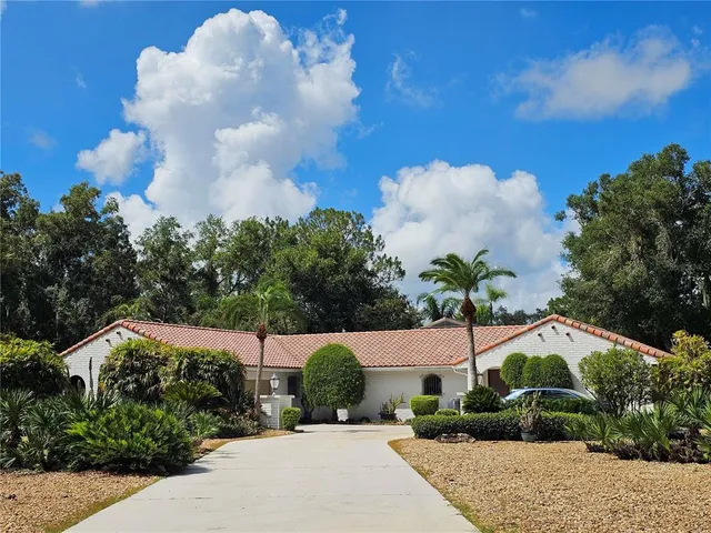 an aerial view of a house with a yard and large trees