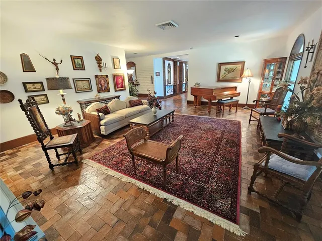 a dining room with furniture and a floor to ceiling window