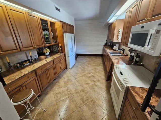 a view of a kitchen with fridge and workspace