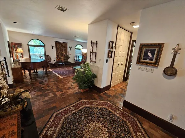 a hallway with painting on the wall and a wooden floor