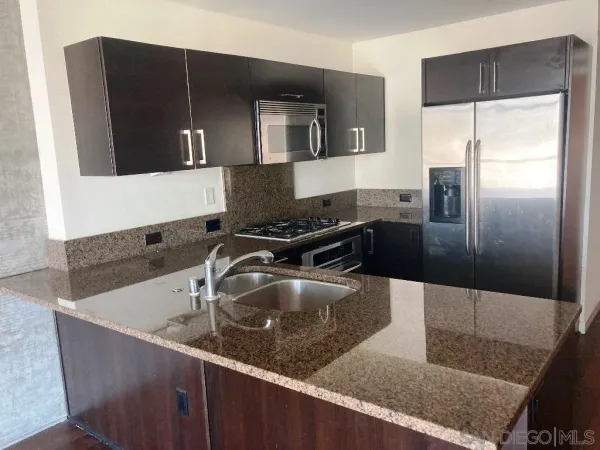 a kitchen with granite countertop a sink and stainless steel appliances