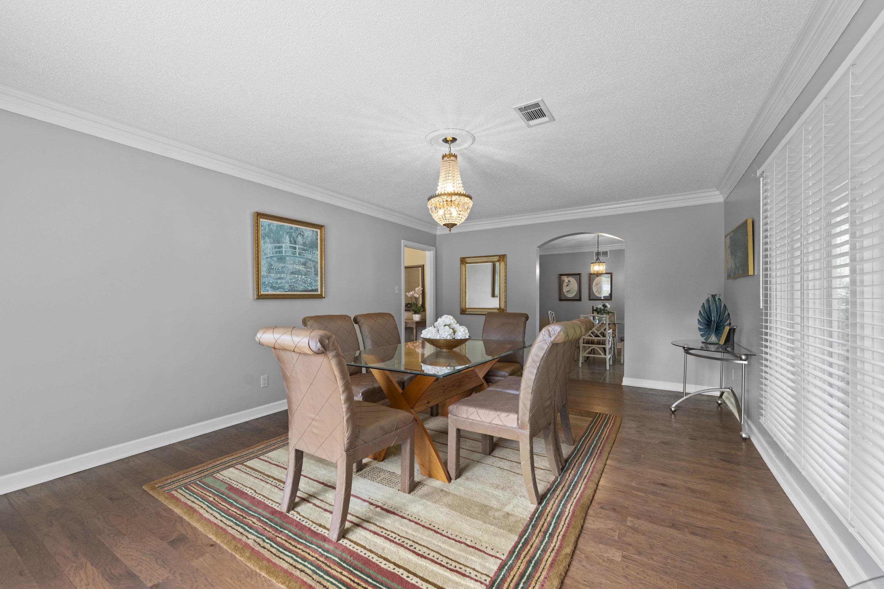 219 North Rose Road Memphis, TN 38117 - Photo 11 of 30 Entertain in the formal dining room featuring arched walkways, ornamental molding, dark hardwood floors, and a chandelier.